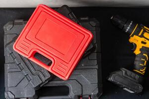 Red Tool Case on Black Toolboxes with Power Drill photo