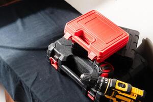 Collection of Toolboxes and Power Drill on Black Surface photo