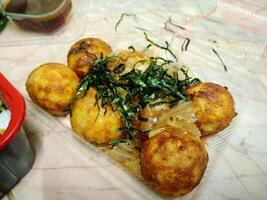 Delicious Takoyaki with Seaweed Garnish, Takoyaki Ball,Japanese Food in transparent plastic box photo