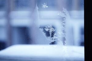Close up of an abstract blurred freezing patterns on the window, glass with copy space. Blue blurred background photo