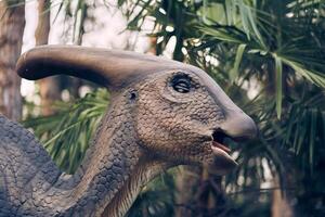 Dinosaur head close-up in the park. A giant parasaurolophus on display in the park on a sunny summer day with space to copy photo