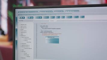 Engineer in home office looking at UI on computer monitor, typing and executing programming code. Close up of person using coding application to write and test code in modern apartment, camera B video