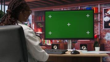 Teleworker at home using isolated screen PC display during job shift, analyzing data at desk, compiling reports. Remote worker doing tasks on chroma key computer, typing information, camera B video