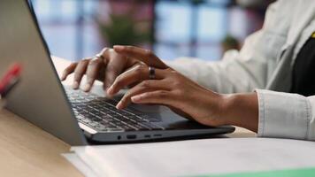 Freelancer in home office sitting at desk and typing on laptop keyboard. Close up of remote worker using electronic device to do customers relations job online, answering inquiries, camera B video