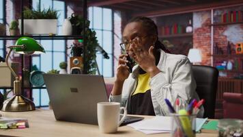 Manager in home office arguing with employee during phone call, looking at laptop. Team leader scolding worker during telephone call after finding errors in documents, camera A video