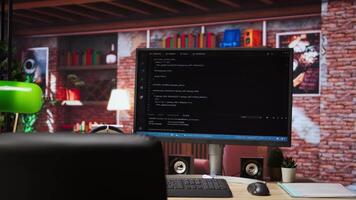 Code typed into PC entering commands and running script, panning shot of monitor on desk. Computer display in apartment used for fixing errors in application and implementing features video