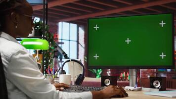 Woman at home using green screen PC during job shift, analyzing data at desk, compiling analytical reports. Remote employee doing tasks on mockup computer, typing information, camera A video