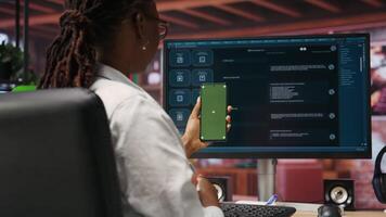 Woman uses green screen phone, doing videocall in front of PC screen with AI LLM chatbot answering prompt. Person uses large language model program during teleconference on mockup smartphone, camera B video