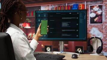 Woman at home holding mockup smartphone asks questions to AI LLM virtual assistant answering prompts. Person with chroma key phone receiving information from artificial intelligence GPT, camera A video