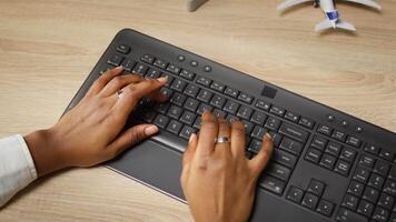 Person at home office desk typing on PC keyboard next to coffee mug, close up shot. Remote employee in apartment pressing computer peripheral keys, inputting data, camera A video