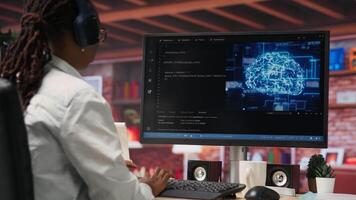 Admin doing maintenance on artificial intelligence neural networks computerized model, listening music. Tech support specialist wearing headphones doing checkup on AI systems, camera B video