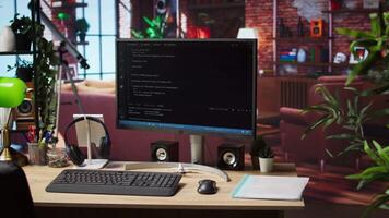 Programming language code editor software UI on computer display in home workspace, jib down shot. Lines of code displayed on PC monitor used to power digital software apps video