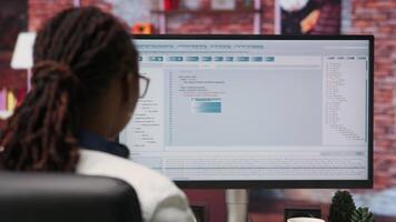 Woman in home office looking at UI on PC screen, typing and executing programming code. Coding application UI used by IT developer writing and testing code in modern apartment, camera B video