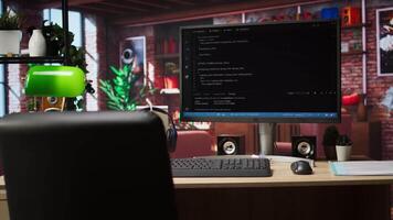 Development console visible on computer screen in modern apartment workspace. Software tools and lines of code displayed on PC monitor in home living room, technology concept video