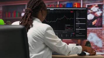 dag näringsidkare använder sig av pc till inköp och sälja lager, läsning filer, siktar till kapitalisera på marknadsföra trender och fluktuationer. investerare spårning stock forex trender på dator övervaka, kamera b video