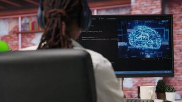 IT engineer drinking coffee, using computer at home for artificial intelligence computing. Close up of remote worker working with AI deep neural networks on desktop PC, camera B video