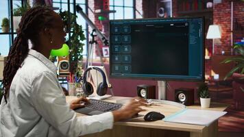Woman seated at desk using AI LLM chatbot software in modern urban home office. Person requesting help from large language model program on computer in bright apartment workspace, camera A video