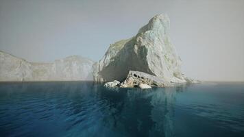 Misty morning view of a rocky outcrop along the tranquil waters of Spain video