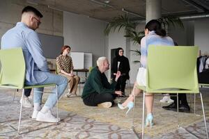 Corporate business team meeting with a manager or coach. Group of happy diverse, multiracial people sitting in a circle photo