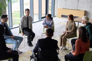Corporate business team meeting with a manager or coach. Group of happy diverse, multiracial people sitting in a circle photo