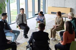 Corporate business team meeting with a manager or coach. Group of happy diverse, multiracial people sitting in a circle photo