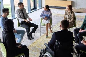 Corporate business team meeting with a manager or coach. Group of happy diverse, multiracial people sitting in a circle photo