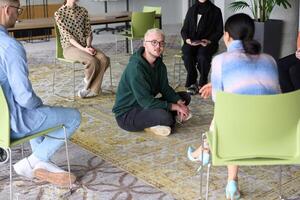 Corporate business team meeting with a manager or coach. Group of happy diverse, multiracial people sitting in a circle photo