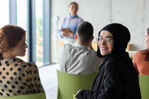 A diverse group of business professionals sits attentively in a modern office, actively participating in a training session led by an instructor, focusing on the latest technological advancements in photo