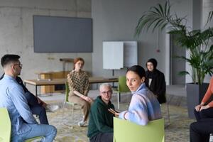 A diverse group of business professionals sits attentively in a modern office, actively participating in a training session led by an instructor, focusing on the latest technological advancements in photo