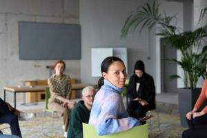 A diverse group of business professionals sits attentively in a modern office, actively participating in a training session led by an instructor, focusing on the latest technological advancements in photo