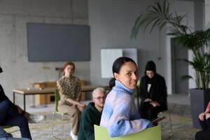 A diverse group of business professionals sits attentively in a modern office, actively participating in a training session led by an instructor, focusing on the latest technological advancements in photo