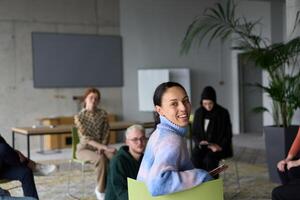 A diverse group of business professionals sits attentively in a modern office, actively participating in a training session led by an instructor, focusing on the latest technological advancements in photo