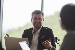 A diverse multiethnic business team engages in a collaborative meeting, discussing strategies and solutions in a modern office setting photo