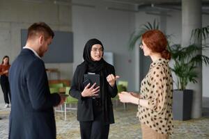 A business team engages in a lively discussion during a coffee break, exchanging challenges and sharing moments of laughter, fostering a positive and collaborative work environment photo