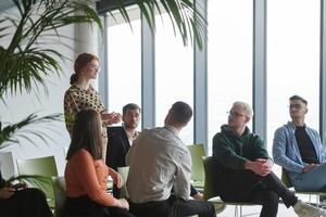 A diverse group of business professionals sits attentively in a modern office, actively participating in a training session led by an instructor, focusing on the latest technological advancements in photo