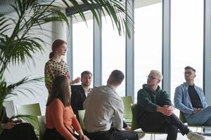 A diverse group of business professionals sits attentively in a modern office, actively participating in a training session led by an instructor, focusing on the latest technological advancements in photo