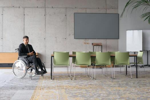 A director in a wheelchair sitting alone in an empty office, deeply reflecting on business strategies and decisions, contemplating the path forward with focused determination. photo