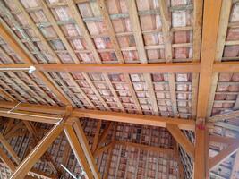 The roof frame of a building is made of solid wood, with clay tiles, with aesthetic shape photo