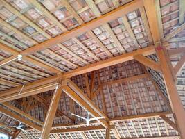 The roof frame of a building is made of solid wood, with clay tiles, with aesthetic shape photo