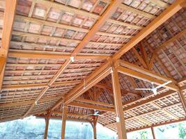 The roof frame of a building is made of solid wood, with clay tiles, with aesthetic shape photo