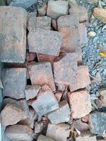 Red broken bricks made of clay, in broken and messy condition photo
