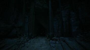 Mysterious cave entrance surrounded by ancient stone structures at dusk video