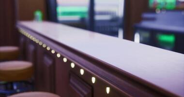 Modern bar counter with soft lighting and wooden finish in a social setting video