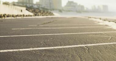 Parking lot by the beach at sunrise with visible cracks in the pavement video