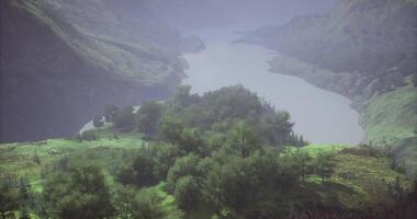 Scenic view of a tranquil river surrounded by lush green hills at sunrise video