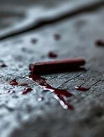 Moody Scene with Fallen Red Wax on Textured Surface in Low Light photo