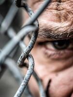 Eye peering through chain link fence focusing on boundary and confinement concepts photo