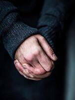 Close-up of Rough Hands Clasped Together in a Gesture of Support and Unity photo