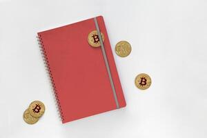 3d illustration of Bitcoins with red leather notebooks isolated on gray background. with clipping path photo