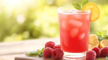 Summertime raspberry lemonade with ice served in a clear glass garnished with fruits photo